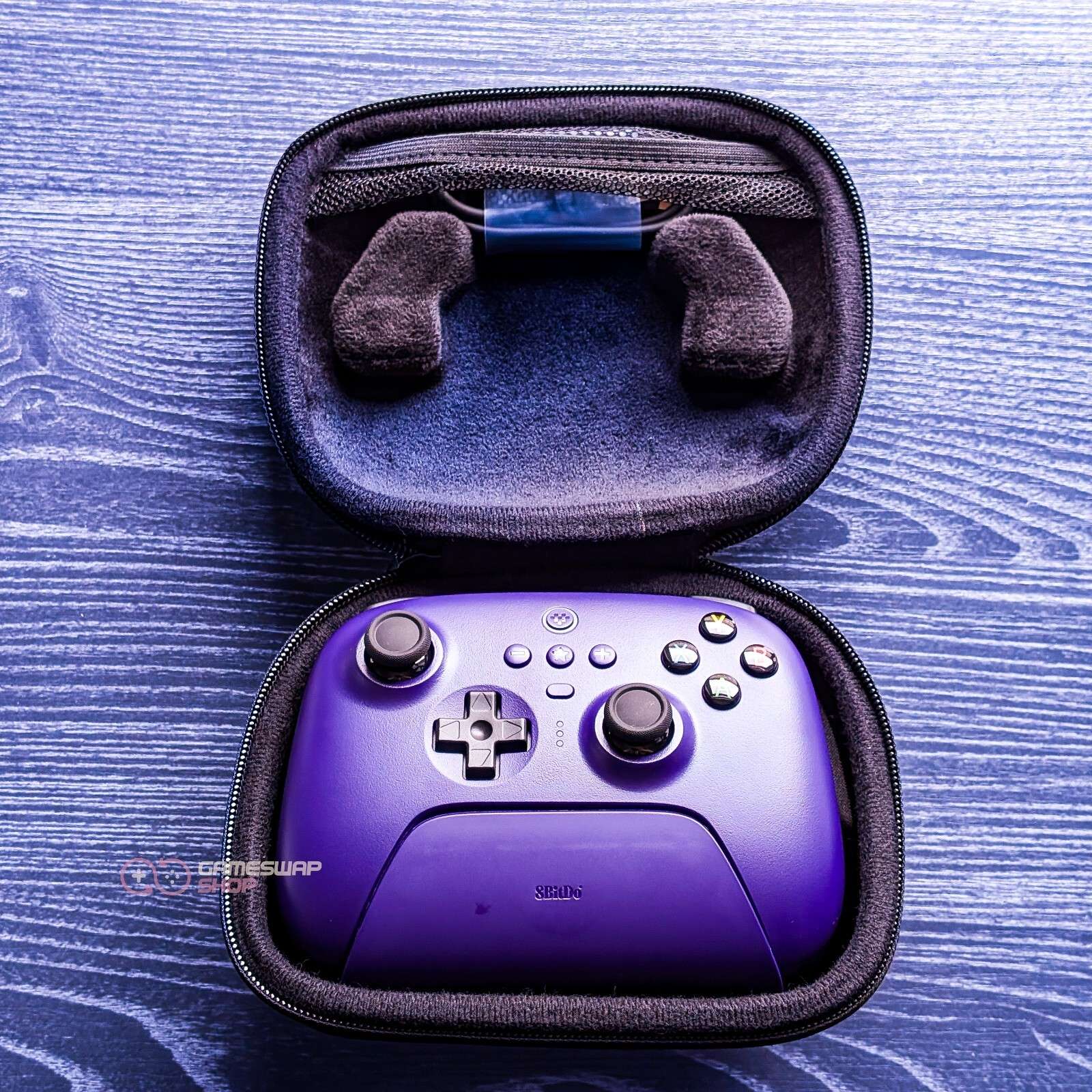 Purple gaming controller inside black zippered case