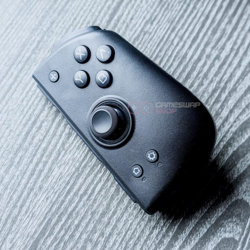 Black gaming controller on wooden surface