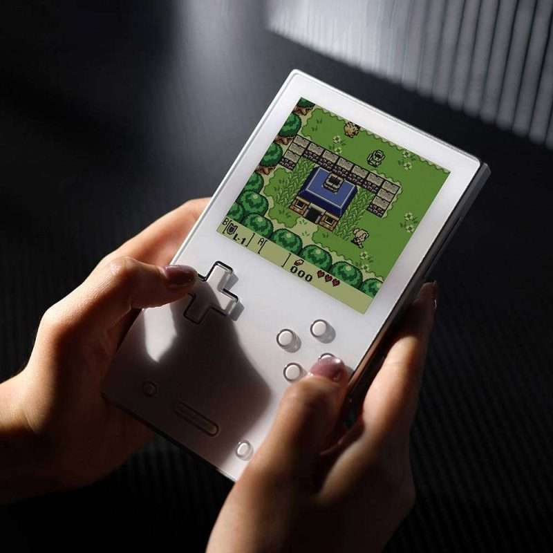 Person playing retro handheld video game console.